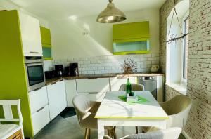 a kitchen with green and white cabinets and a table at FEWO-Hagemeister in Schwerin - ABC571 - keine Monteure in Schwerin