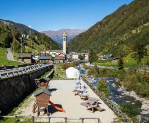 a beach with chairs and tables and a river at Casa Bavo in Gerola Alta