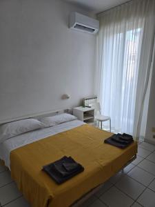 a bedroom with a bed with two black towels on it at Hotel Annarita-mezza pensione plus- spiaggia inclusa in Rimini +51 photos