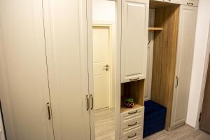 a closet with white cabinets and a plant in it at Q Elegance Palas Mall in Iaşi