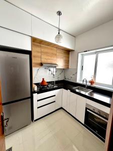 a kitchen with white cabinets and a stainless steel refrigerator at Afalux Brand chic in Agadir