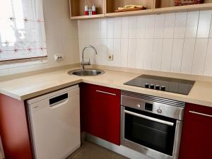 a kitchen with red cabinets and a sink at Calpe Star in Calpe