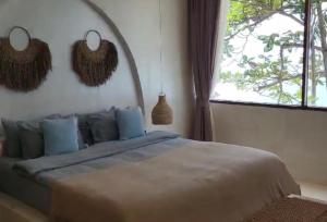 una camera da letto con un letto con cuscini blu e una finestra di Beachfront Villa Demar in Cape Beach Villa Samui a Nathon Bay