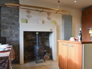 ein Kamin in einer Küche mit Herd in der Unterkunft Garden Cottage in Weem