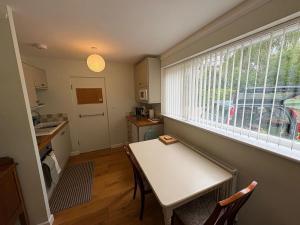 a small kitchen with a table and a window at The River Apartment By RentMyHouse in Hereford