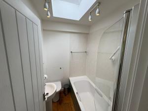 a bathroom with a sink and a tub and a toilet at The River Apartment By RentMyHouse in Hereford +7 photos