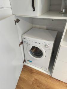 a washer and dryer in a small kitchen at City TinyHouse under WaterTower in Wrocław
