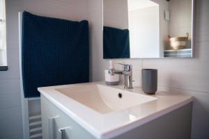 a white bathroom with a sink and a mirror at Gîte la Chapotière proche du Puy du Fou in La Verrie