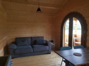 a living room with a blue couch and a table at Chalet 4 personnes en Sologne in Neung-sur-Beuvron