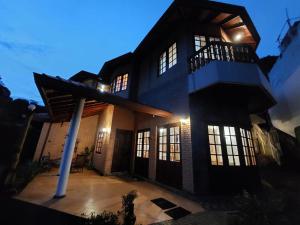 una grande casa con portico e luci accese di Mystique Hideout a Kandy