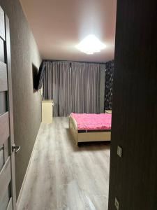 スームィにあるКвартира новострой Харьковскаяのベッドルーム1室(ピンクベッド1台、窓付) +1枚の写真
