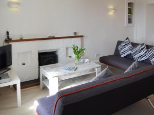 - un salon avec un canapé et une table avec une cheminée dans l'établissement Cobi's Cape Cottage, à Saint Just