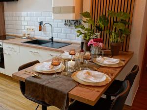 a table with plates and wine glasses on it in a kitchen at Fewo Sweethome Lutherstadt Wittenberg - zentral gelegen in ruhiger Seitenstraße, inklusive Parkplatz und 2 Min Fußweg zur Schlosskirche in Lutherstadt Wittenberg