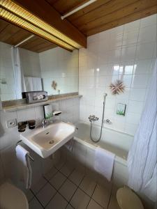 a white bathroom with a sink and a shower at Hotel Ermitage Verbier in Verbier +47 photos