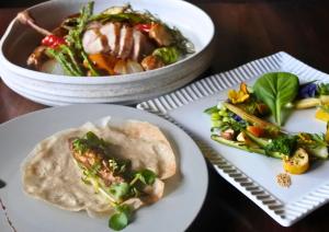 un tavolo con due piatti di cibo e una ciotola di verdure di Satoyama Villa Honjin a Matsumoto