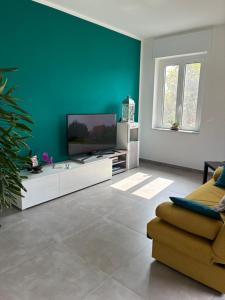 a living room with a flat screen tv on a white cabinet at Villa Fiorita in San Maurizio Canavese