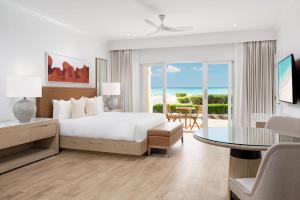 una camera d'albergo con letto e tavolo e una camera di Alexandra Resort - All Inclusive a Grace Bay