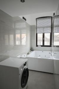 Un baño blanco con bañera y lavadora. en EMA Exclusive Locations GmbH, en Limburg an der Lahn 37 fotos más