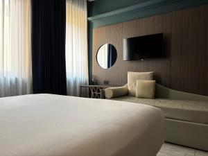 a hotel room with a large bed and a television at AV Hotel Milano in Milan