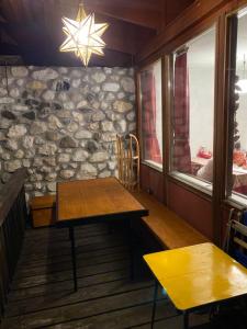 a table in a room with a stone wall at Chalet La Stella a Corte in Borca di Cadore