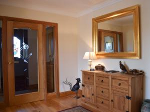 a room with a wooden dresser and a mirror at Lawford Lodge in Bonnybridge