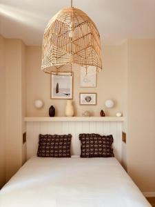 1 dormitorio con 1 cama con lámpara de araña encima en Sézam-Appart-Hôtel, en Saint-Malo
