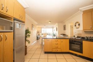 a kitchen with wooden cabinets and a stove top oven at Praslin 4 in Margate