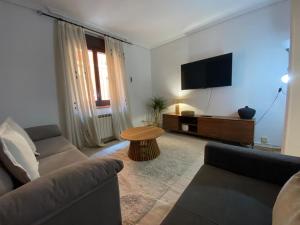 a living room with a couch and a flat screen tv at Tejería 43 by Clabao in Pamplona