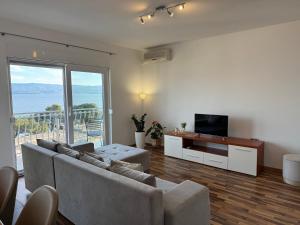 a living room with a couch and a television at Apartment Marino 2 in Duće