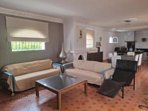 un salon avec deux canapés et une table dans l'établissement Magnifique villa piscine Ghazoua, à Al Ghar