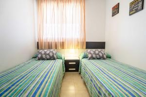 two twin beds in a room with a window at Colomeras Vidaber in Oropesa del Mar