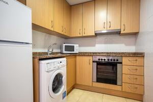 a kitchen with a washing machine and a microwave at Colomeras Vidaber in Oropesa del Mar