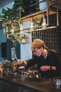 a man standing at a bar making a drink at Meteorologen Ski Lodge in Riksgränsen