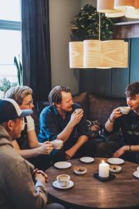 a group of people sitting around a table drinking coffee at Meteorologen Ski Lodge in Riksgränsen