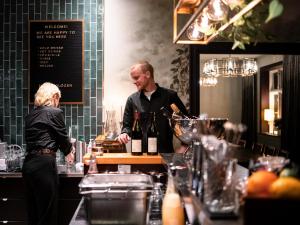 a man and a woman standing behind a counter in a kitchen at Meteorologen Ski Lodge in Riksgränsen
