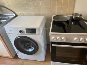 a stove and a washing machine with a pot on it at Villa Lakeview Paradise in Peštani