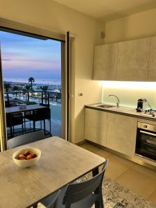 a kitchen with a table with a bowl of fruit on it at Roseto Marina Lungomare in Roseto degli Abruzzi