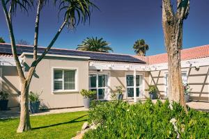 a house with palm trees in front of it at Ocean House Swakopmund in Swakopmund +34 photos