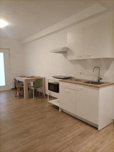 a kitchen with white cabinets and a table with chairs at D&Dhome in Mola di Bari +14 photos