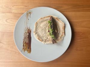 un piatto bianco con un panino su un tavolo di Satoyama Villa Honjin a Matsumoto