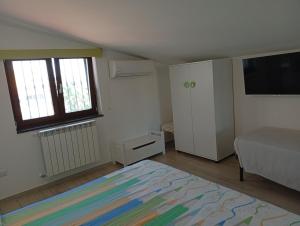 ein Schlafzimmer mit einem Bett und einem Flachbildfernseher in der Unterkunft La Maison di Sara in Santa Maria La Carità