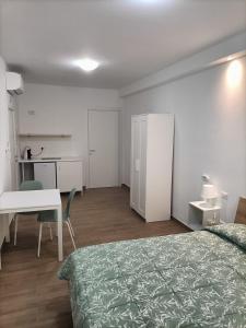 a bedroom with a bed and a desk and a table at D&Dhome in Mola di Bari