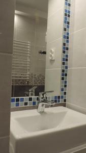 een badkamer met een witte wastafel en een spiegel bij Apartament Grey in Iwonicz-Zdrój