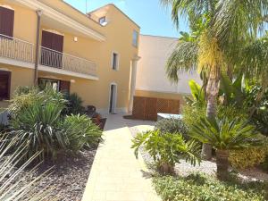 un patio de un edificio con palmeras y plantas en L'OASI DI CICCIO, en Mazara del Vallo