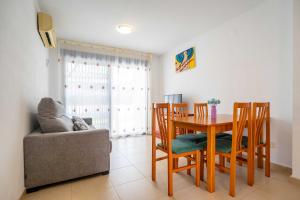 a dining room with a table and chairs and a couch at Villablanca Vidaber in Oropesa del Mar