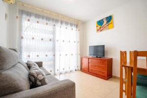 a living room with a couch and a television at Villablanca Vidaber in Oropesa del Mar