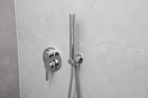 a shower with a shower head in a bathroom at A&K Apartments in Sarandë +36 photos