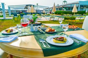 een tafel met borden met eten en glazen wijn bij Karya Family Resort Hotel All Inclusive in Ozdere