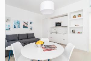 a white living room with a white table and chairs at Puolo Seaside Apartment 3 in Massa Lubrense