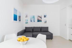 a living room with a couch and a table with oranges on it at Puolo Seaside Apartment 3 in Massa Lubrense